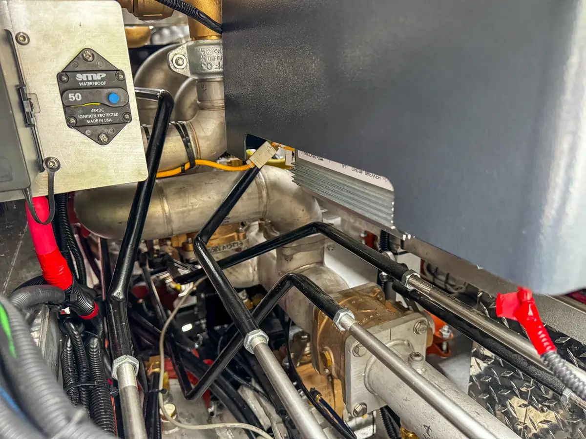 Service compartment interior close-up with plumbing lines and electrical harnesses.